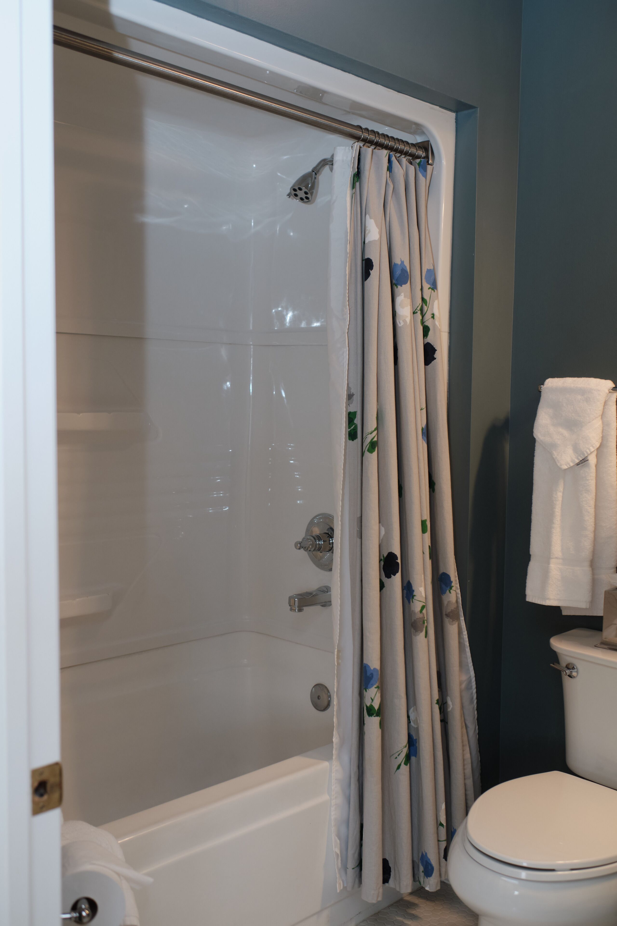 Un bagno con tenda da doccia, vasca e water.