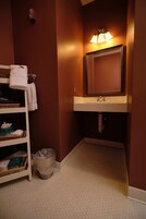 A bathroom with a white sink, mirror, and a towel rack with towels.