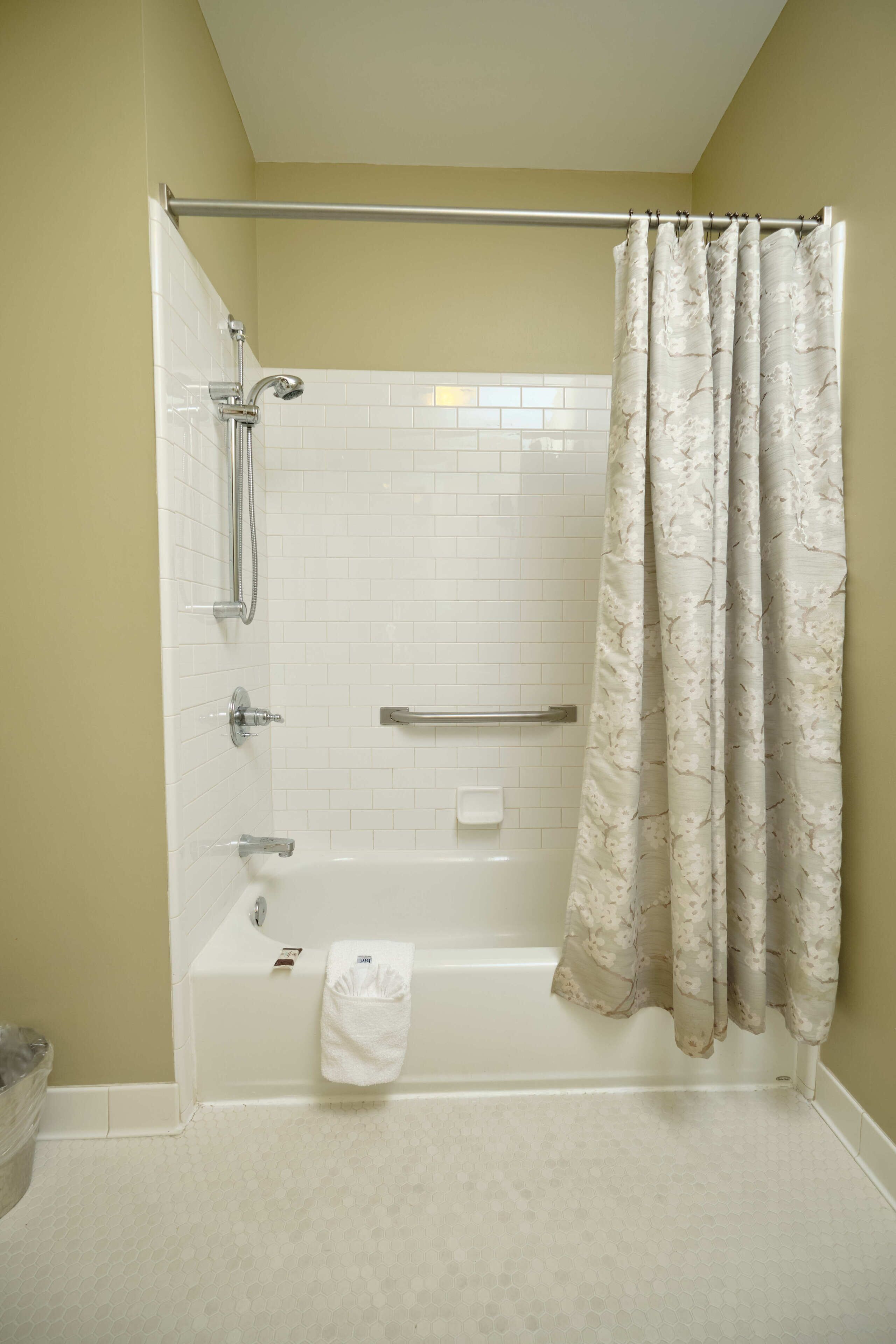 A bathroom with a shower, toilet, and bathtub.
