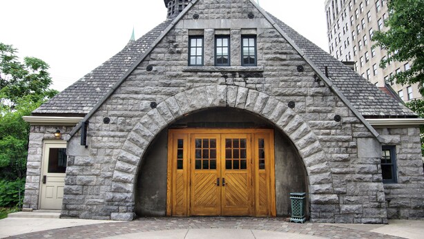 A stone building with a large wooden door and a pointed roof. - The Inn on Ferry Street (Detroit)