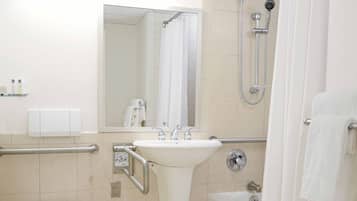 Baño con inodoro, lavamanos, ducha y espejo.