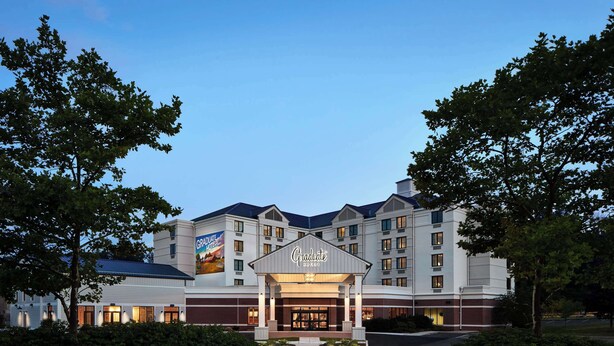 A multi-story hotel with a prominent entrance and a large sign. - Graduate by Hilton Storrs (Storrs)