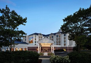 A multi-story hotel with a prominent entrance and a large sign.