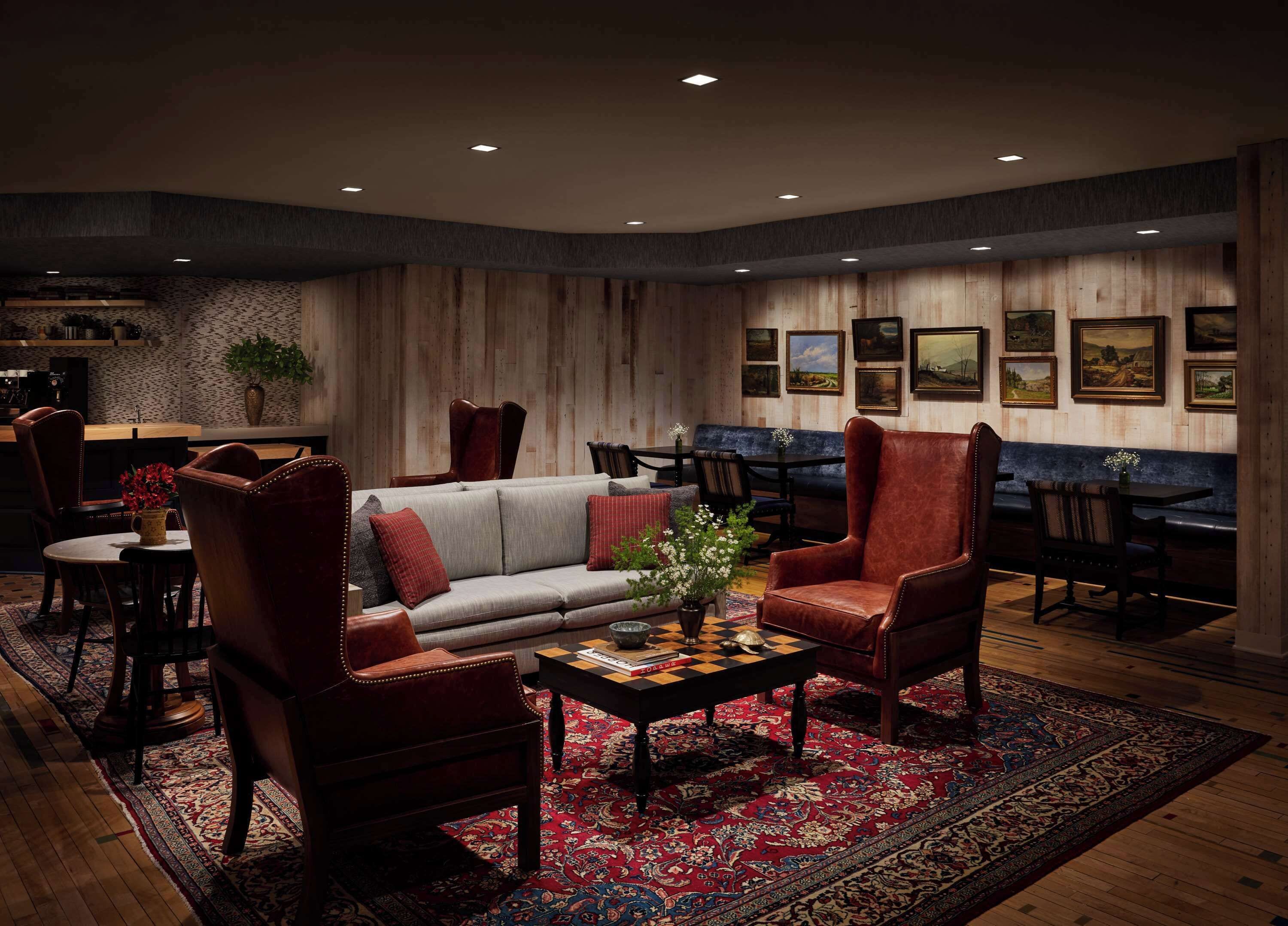 Una sala de estar acogedora con un sofá, sillones, una mesa de centro y un comedor con una mesa y sillas.