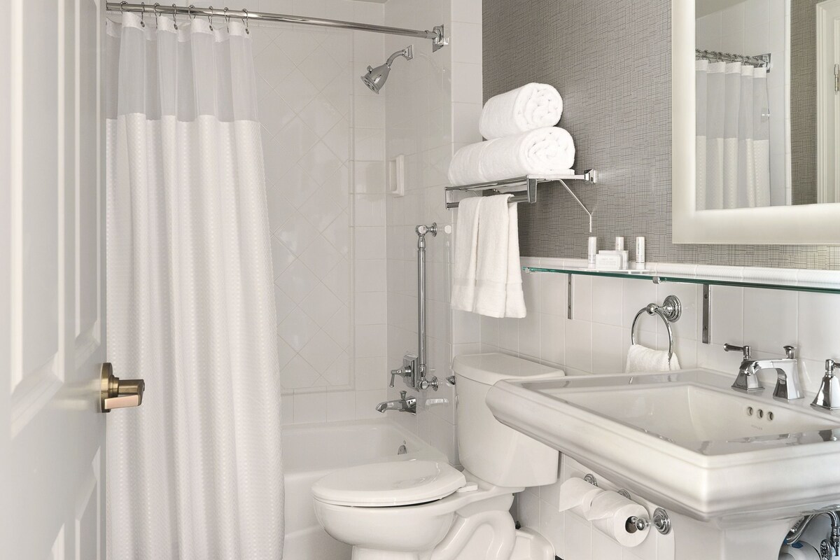 A modern bathroom with a shower, toilet, and sink.