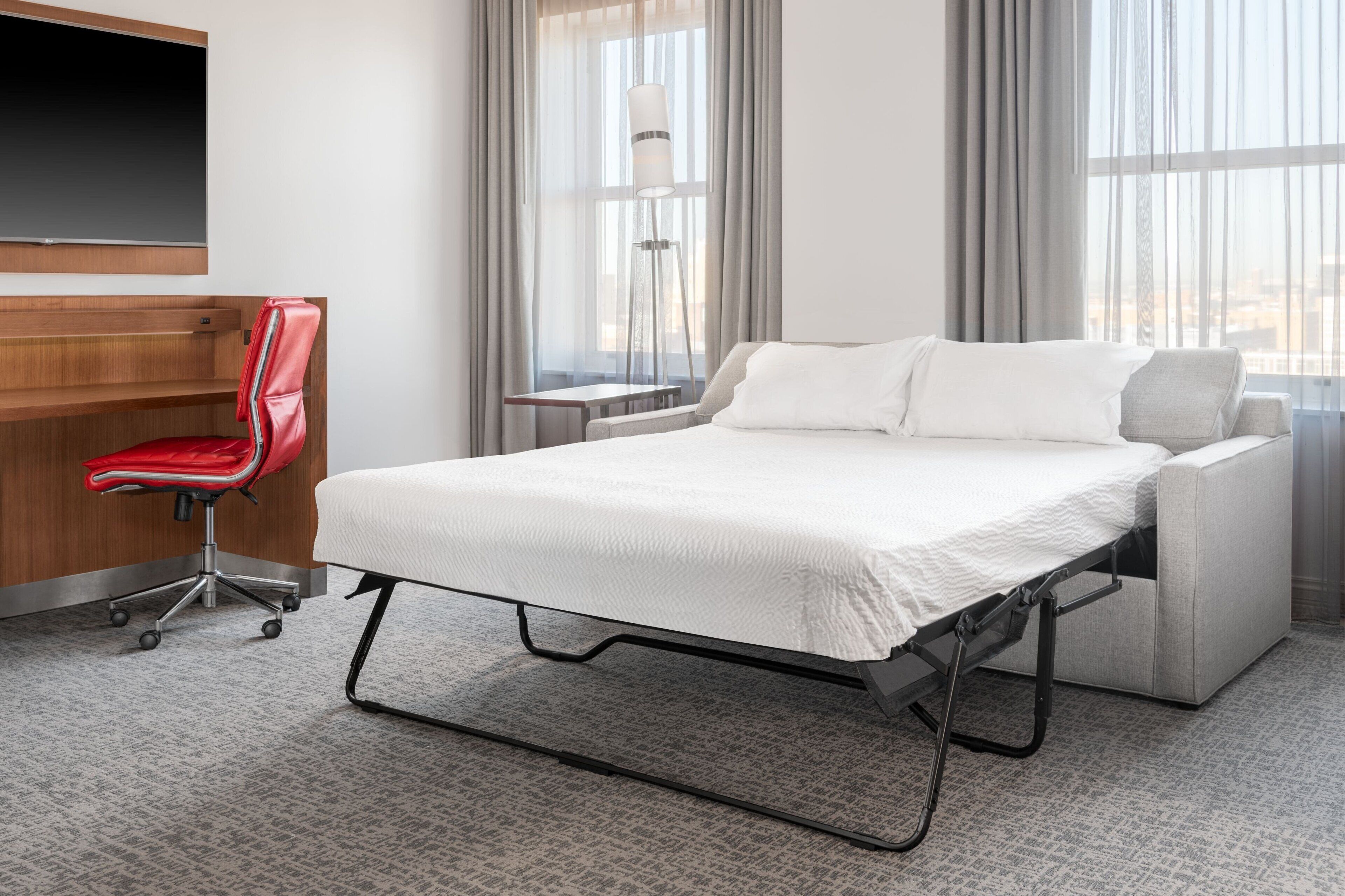 Een hotelkamer met een bed, een bureau en een stoel.