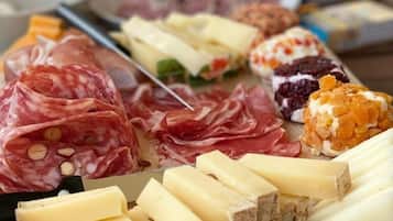 Une planche de charcuterie avec différentes sortes de viandes, de fromages et de fruits.