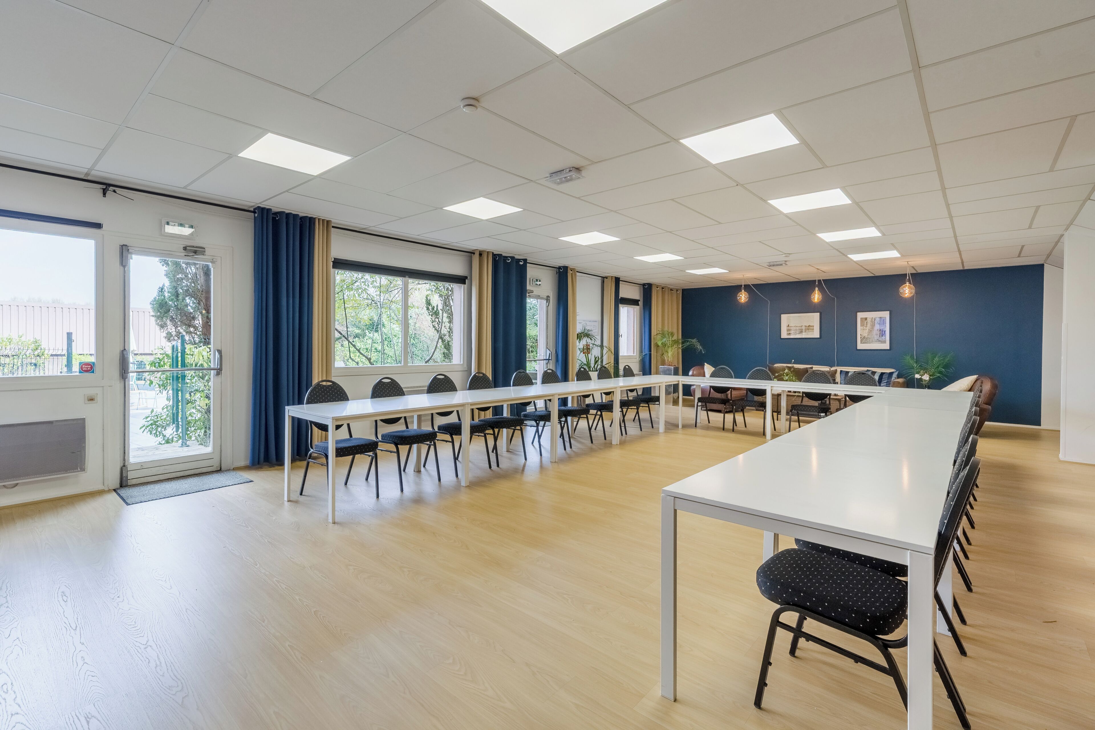 A conference room with a long table, chairs, and a whiteboard.