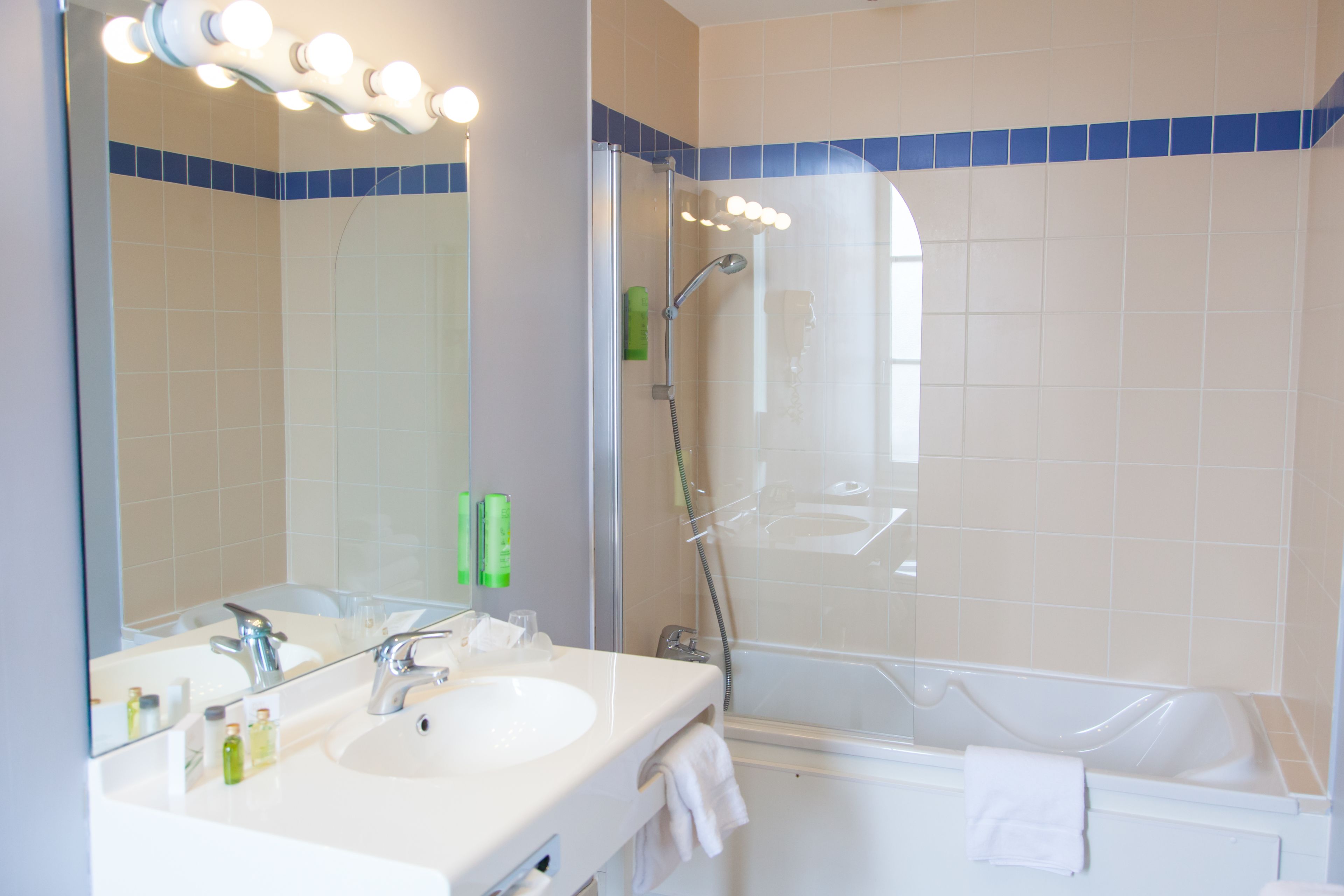 Un baño con lavamanos, espejo y ducha.