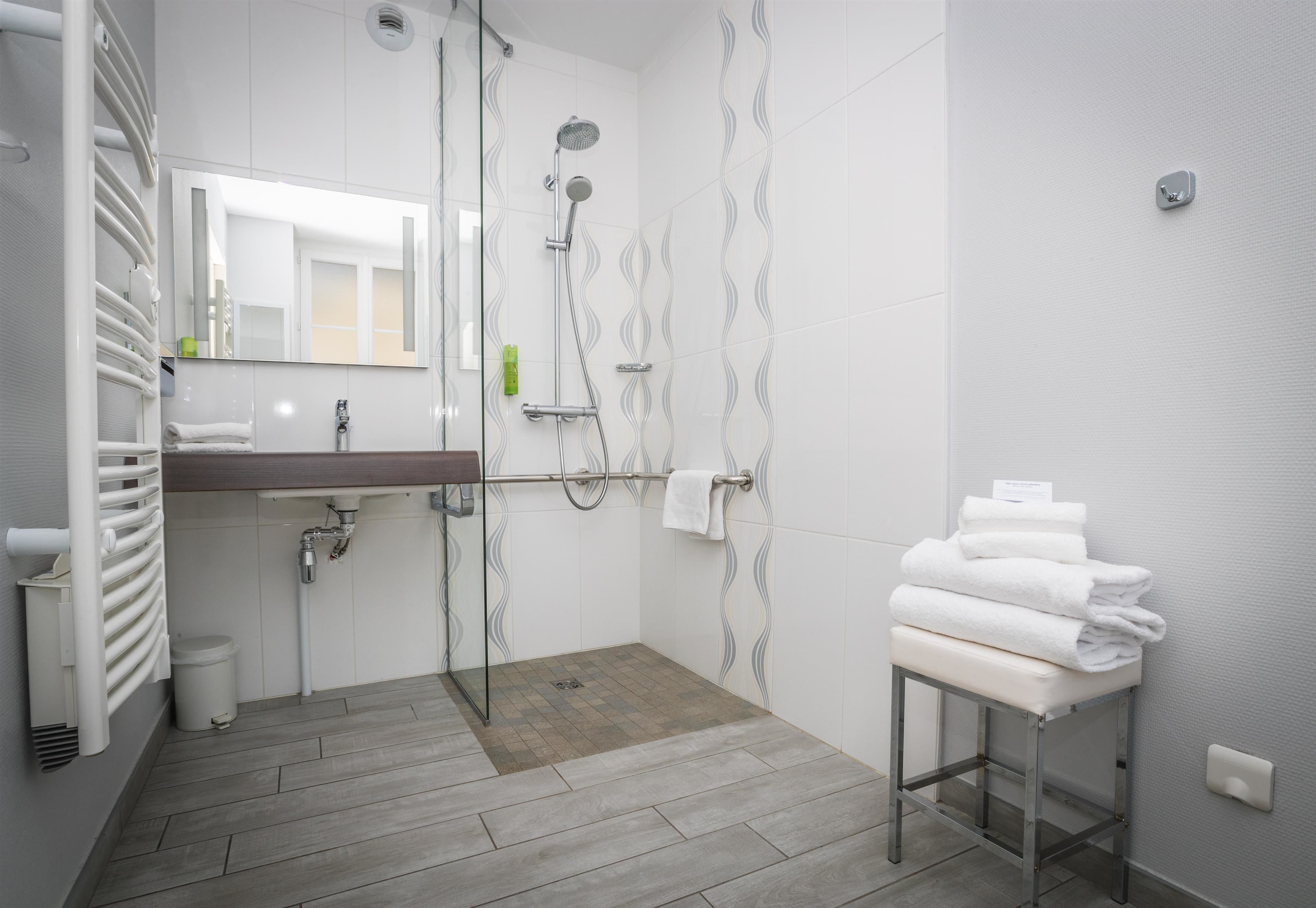 A modern bathroom with a shower, a sink, and a toilet.