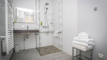 A modern bathroom with a shower, a sink, and a toilet.