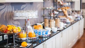 A buffet with various fruits, juices, and breakfast items.