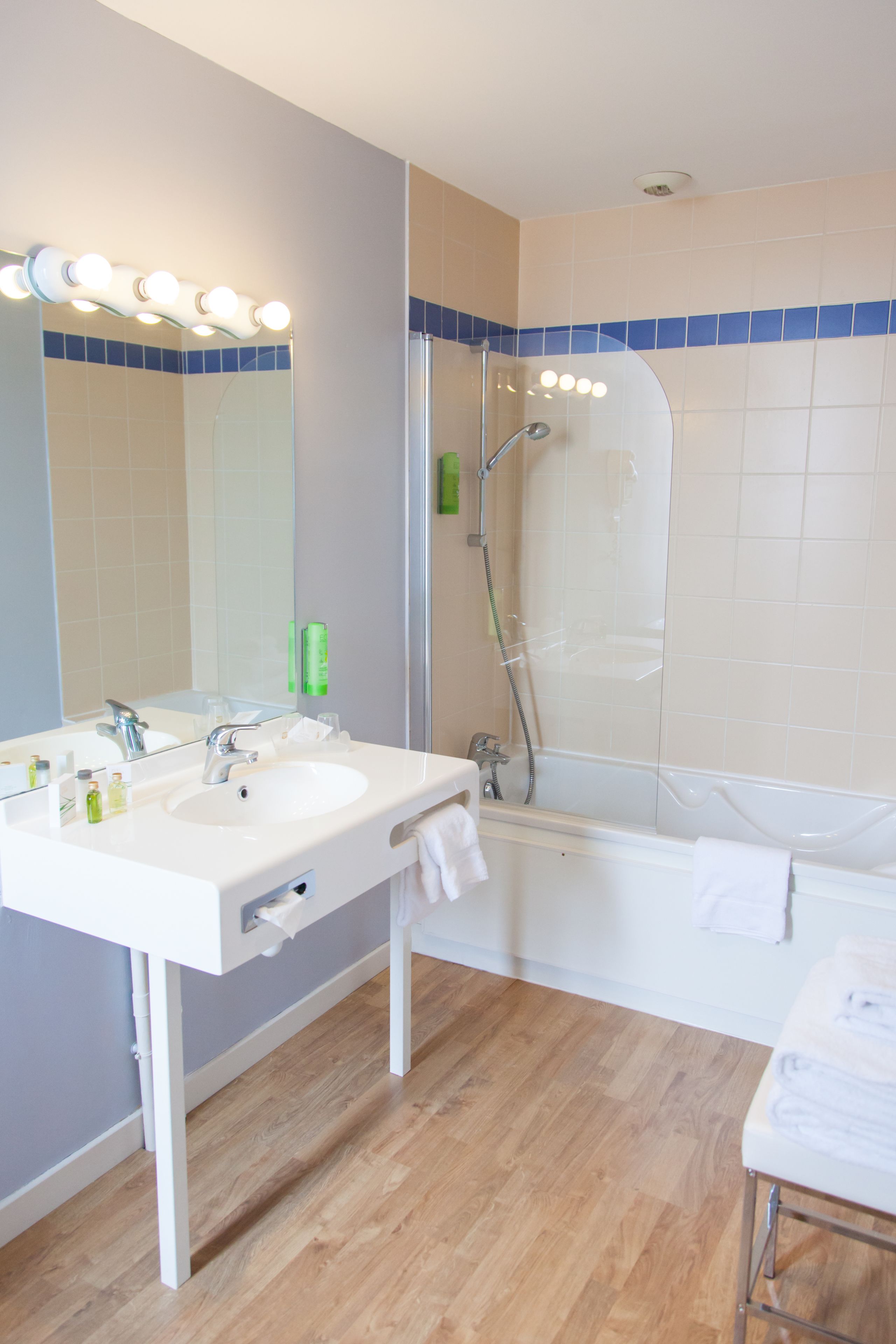 Une salle de bain avec deux lavabos, un miroir et une douche.