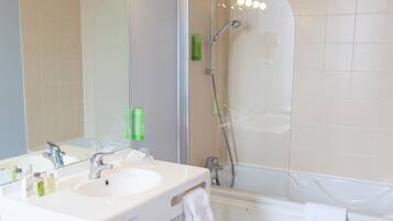 Une salle de bain avec deux lavabos, un miroir et une douche.