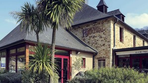 A stone building with a red door and a sign that reads "LOUNGE". - Mercure Dinan Port Le Jerzual (Lanvallay)