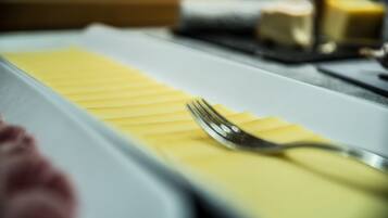 A dining table with a white tablecloth, a fork, and a yellow napkin.
