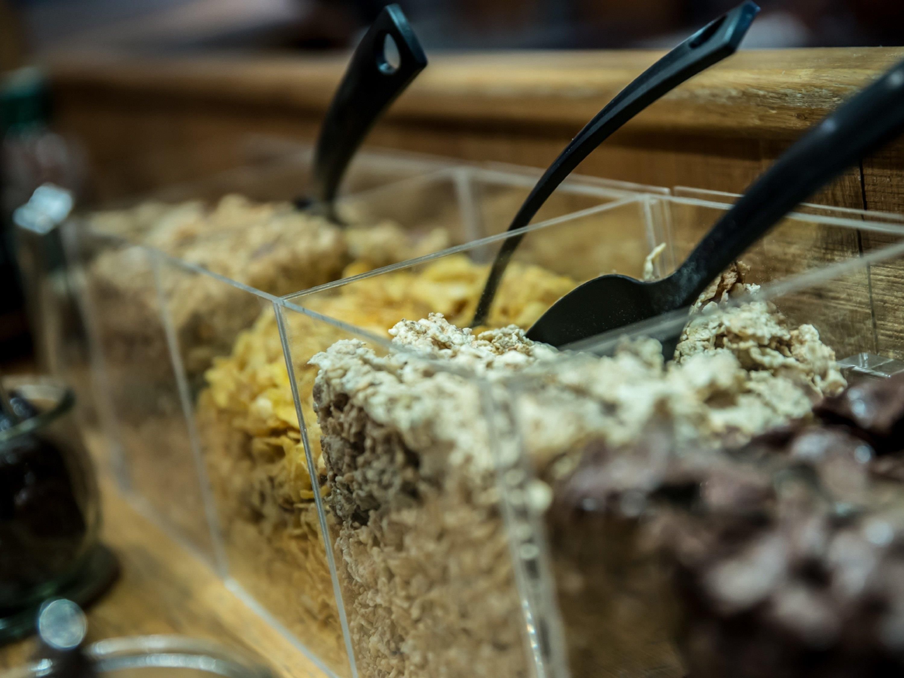 Une présentation de desserts comprenant divers gâteaux et pâtisseries, le tout disposé dans un récipient transparent.