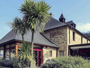 A stone building with a red door and a sign that reads "LOUNGE".