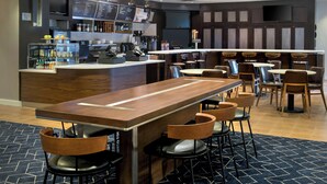 A modern bar area with a long counter, stools, and a menu board. - Courtyard by Marriott Basking Ridge (Basking Ridge)