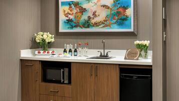A kitchen with a white countertop, wooden cabinets, a microwave, and a dishwasher.