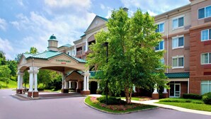 A Marriott Courtyard hotel entrance with a covered walkway, brick facade, and landscaped garden. - Courtyard by Marriott Basking Ridge (Basking Ridge)