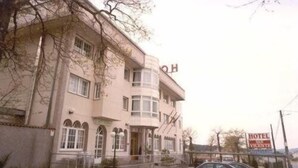 Een gebouw met twee verdiepingen, met een bord waarop 'HOTEL VICENTE' staat.
