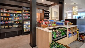 A well-stocked beverage and snack kiosk with a variety of drinks and snacks, including bottled water, soda, and packaged foods. - Hilton Garden Inn Ft Myers (Fort Myers)