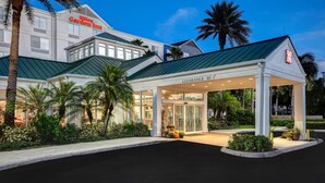 A hotel with a clear entrance, a covered waiting area, and a sign indicating a clearance height of 10'-3". - Hilton Garden Inn Ft Myers (Fort Myers)