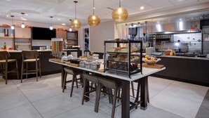 A modern kitchen with a central island, bar stools, and hanging pendant lights. - Hilton Garden Inn Ft Myers (Fort Myers)