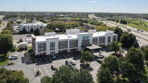 A Hampton Inn Express hotel with a parking lot and a highway in the background. - Holiday Inn Express Hotel & Suites Columbus SW-Grove City by IHG (Grove City)
