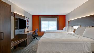 A hotel room with two beds, a desk with a chair, a TV, and a large window.