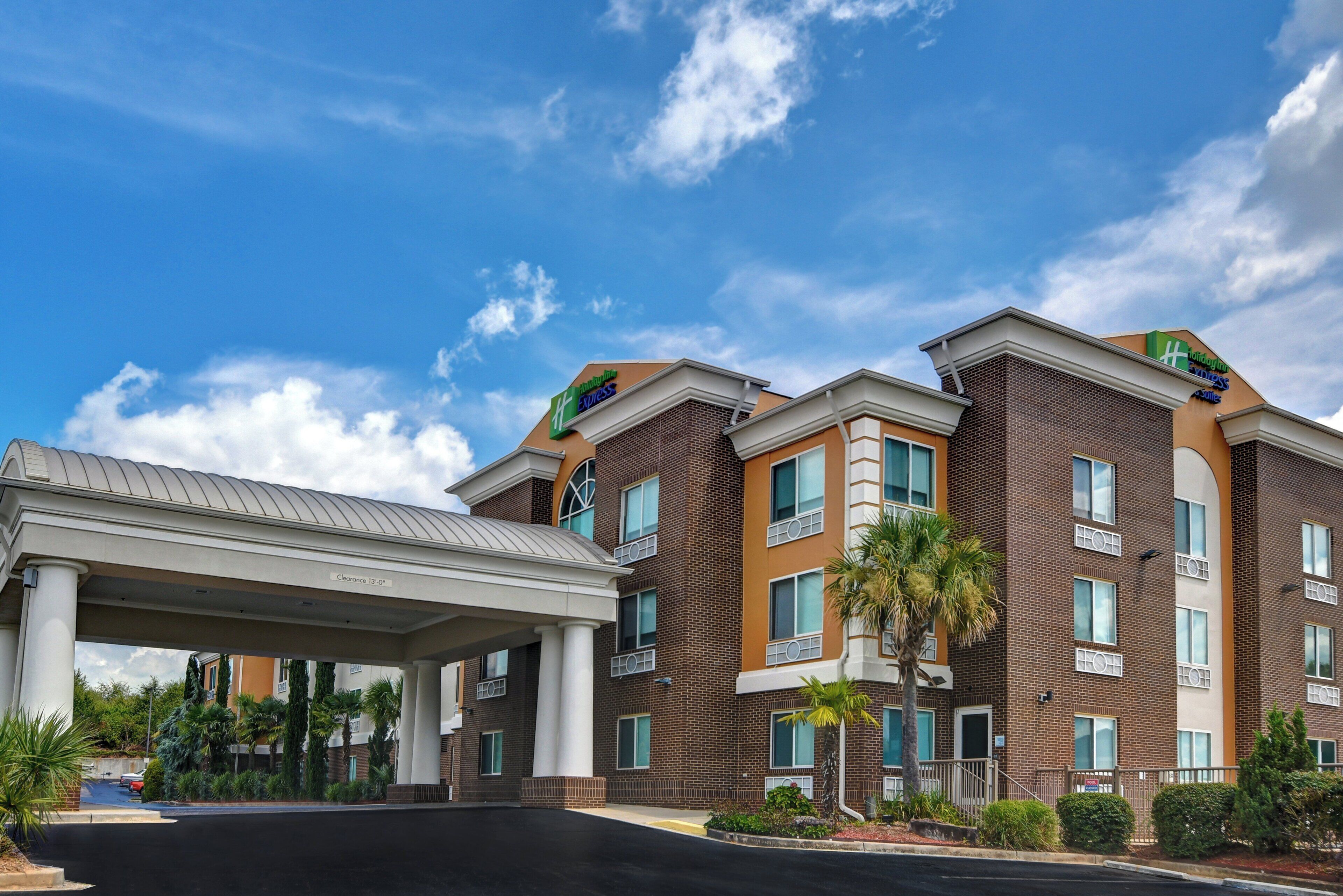 Un hotel Holiday Inn Express con entrada cubierta y cielo despejado.
