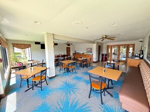 A spacious dining area with multiple tables and chairs, a ceiling fan, and a large window providing natural light. - Days Inn & Suites by Wyndham Cuba (Cuba)