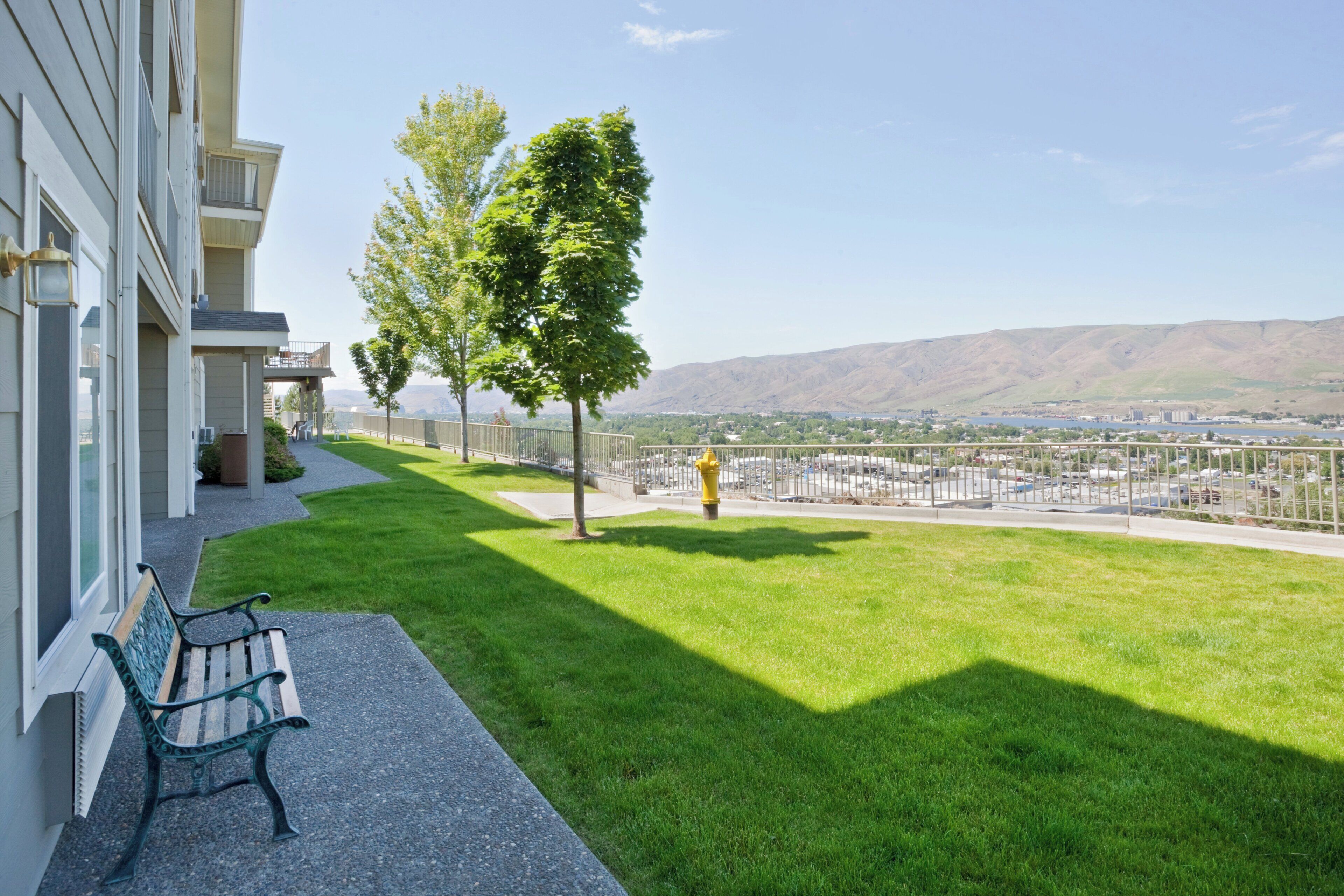 Un balcon d’hôtel offrant une vue sur le paysage urbain et les montagnes.