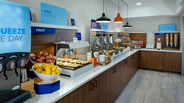 A breakfast buffet with labeled sections for fruit, cereal, and a coffee machine. - Holiday Inn Express Lewiston by IHG (Lewiston)