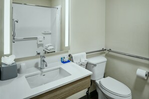 A modern bathroom with a white sink, mirror, and toilet.