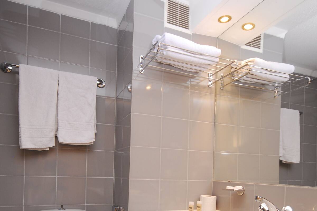 A modern bathroom with a toilet, sink, and towel rack.