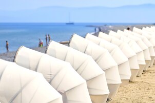 En la playa, camas de playa, sillas reclinables de playa, sombrillas