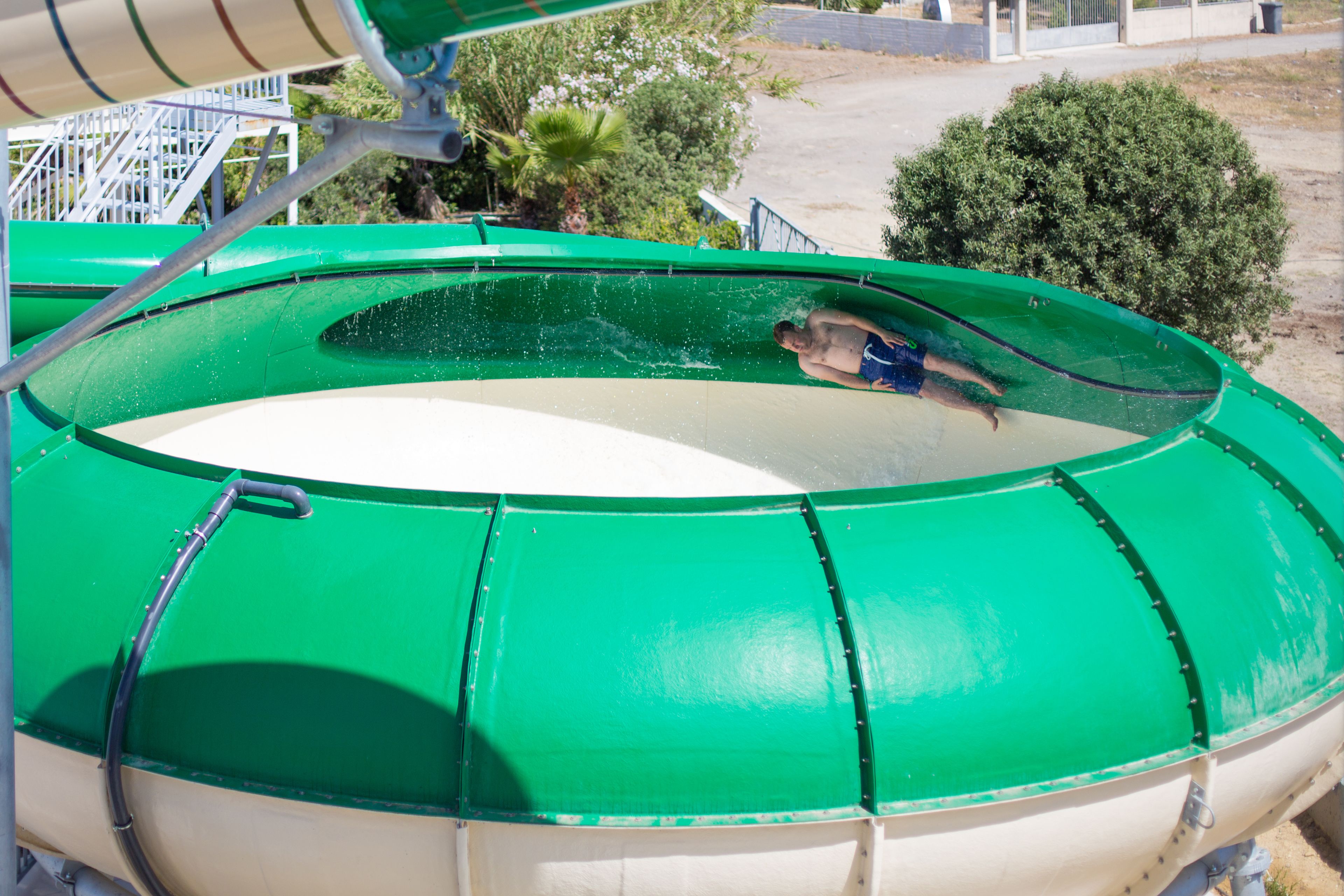 A green water slide with a person at the bottom.