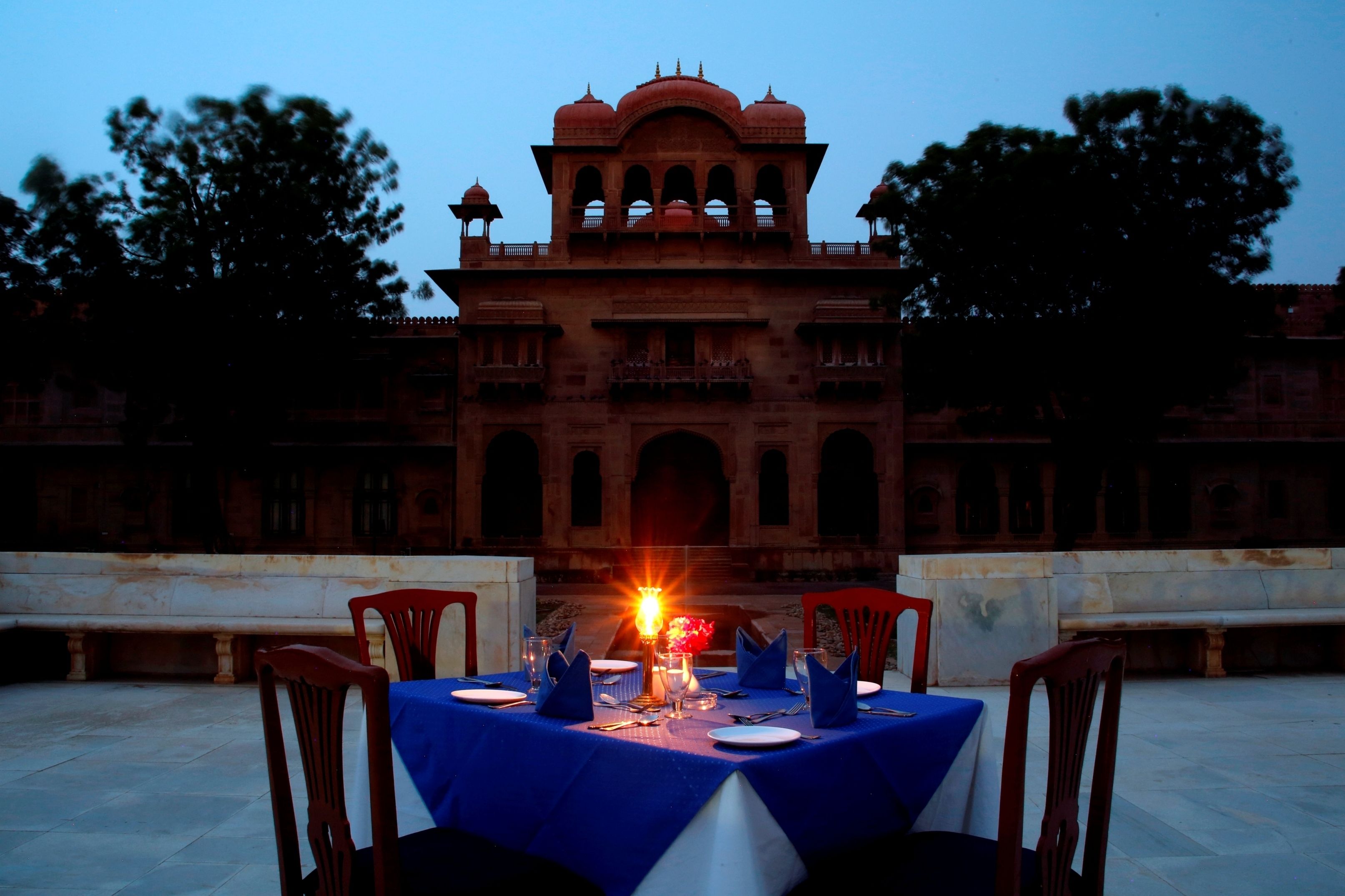 Mesa de comedor al aire libre con vista a un edificio histórico de fondo.