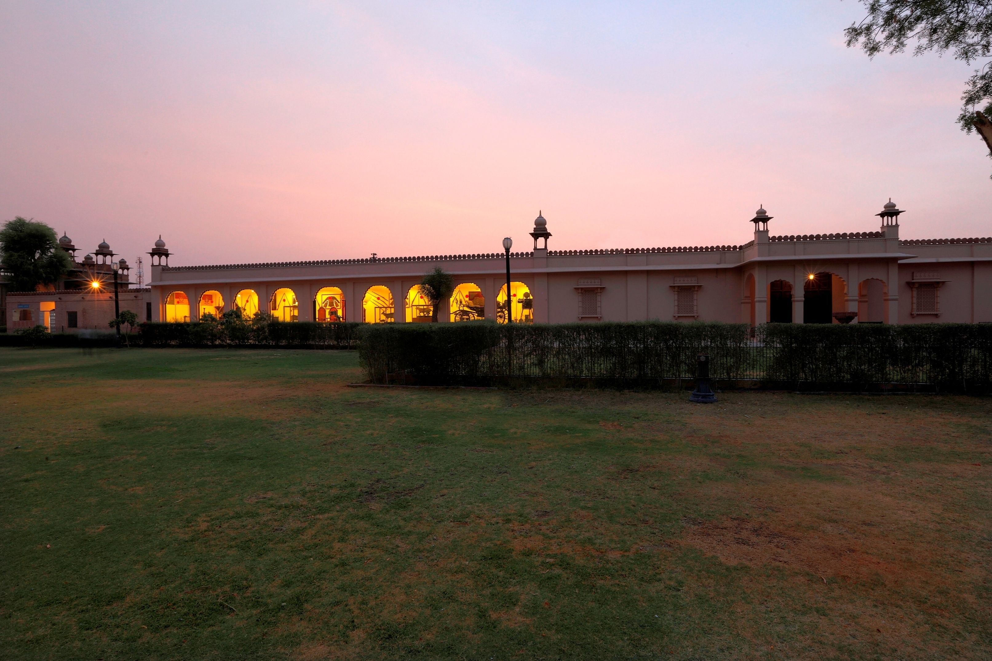 A building with multiple arches and a series of lamp posts.