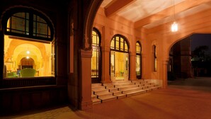A building with a grand entrance, large arched windows, and a well-lit interior. - The Lallgarh Palace - A Heritage Hotel (Bikaner)
