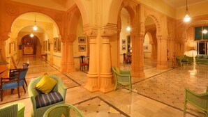 A spacious lobby with high ceilings, ornate columns, and a polished marble floor. - The Lallgarh Palace - A Heritage Hotel (Bikaner)