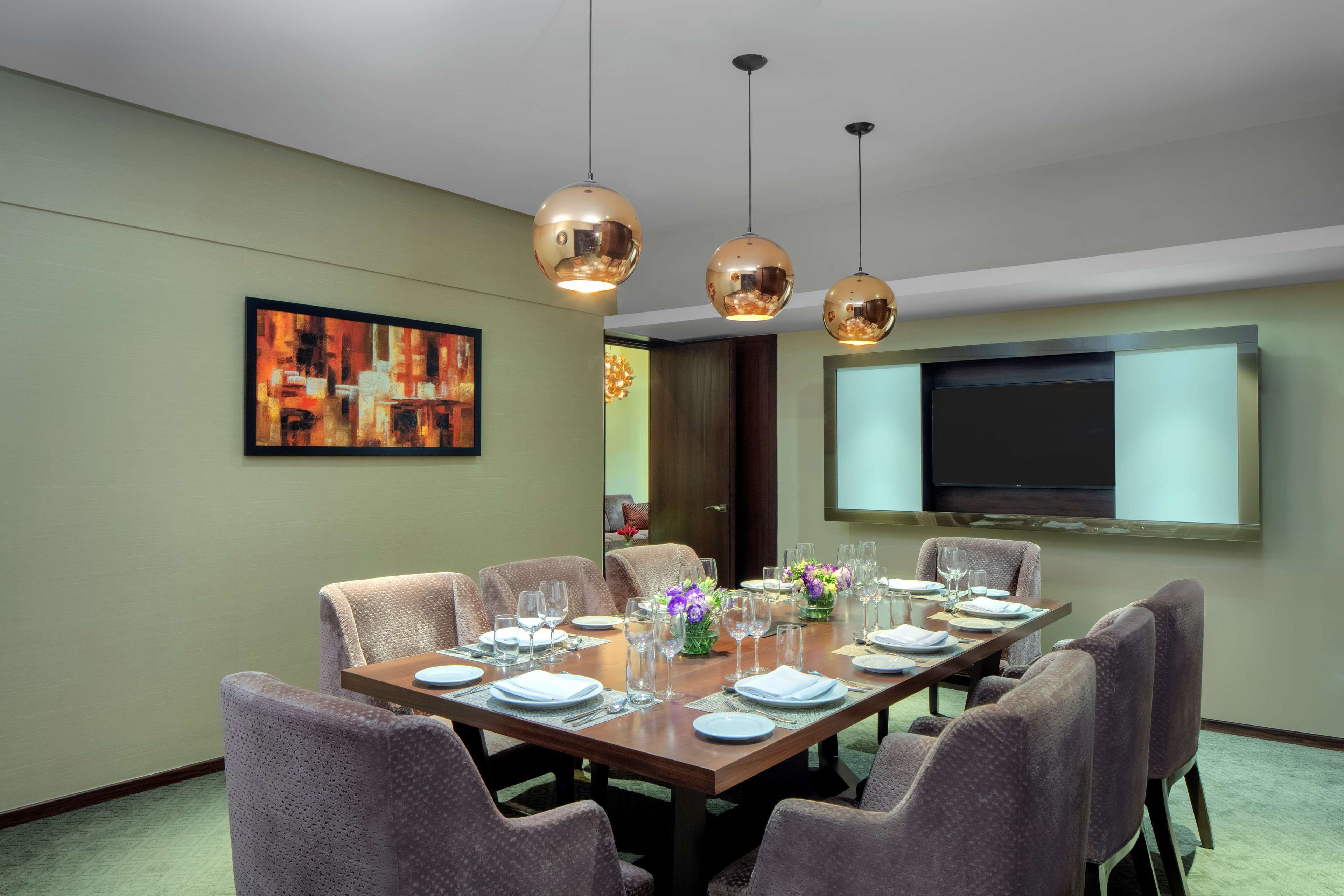 A dining room with a long table set for a meal, surrounded by chairs.