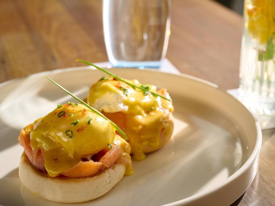 Un plato con dos sándwiches huevos benedictinos.