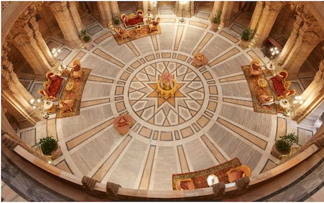 A grand hall with a central star-shaped design, ornate columns, and luxurious seating arrangements.