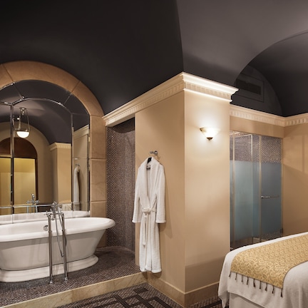 A modern bathroom with a freestanding bathtub, a large mirror, and a separate shower area.