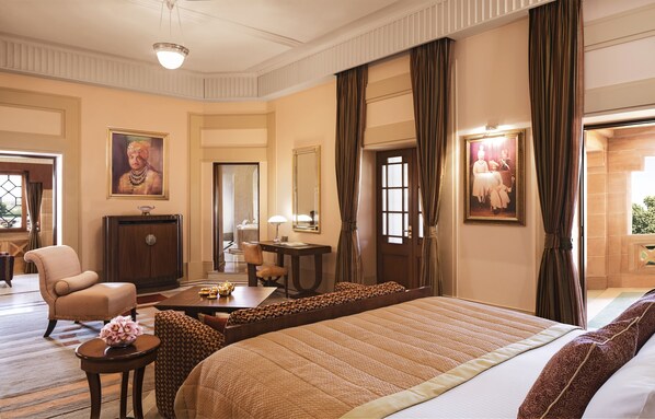 Una habitación de hotel con una cama grande, un escritorio, una silla y un armario.
