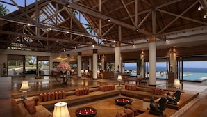 A spacious lobby with a high ceiling, large windows, and a view of the ocean. - The Leela Kovalam, a Raviz Hotel (Neyyattinkara)