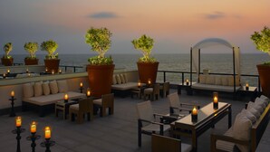 A rooftop terrace with seating, potted plants, and candles. - The Leela Kovalam, a Raviz Hotel (Neyyattinkara)